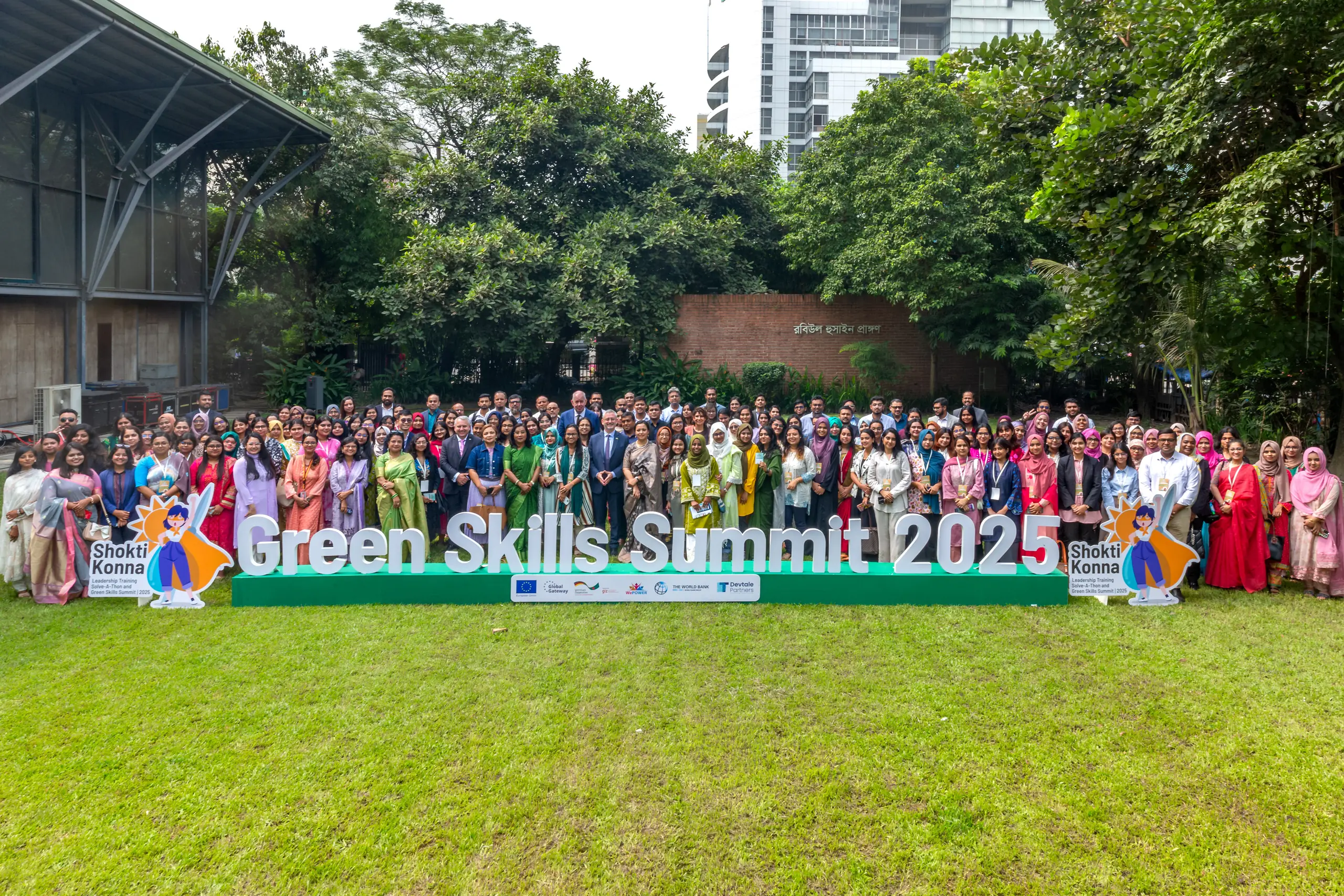 Shoktikonna participants, partners and guests behind the Green Skills Summit 2025 sign in Dhaka